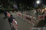 Petugas memeriksa pengguna jalan yang akan masuk kedalam Kota di perbatasan Kota Banjarmasin, Kalimantan Selatan, Jumat (24/4/2020) malam. Saat pemberlakuan jam malam untuk mendukung Pembatasan Sosial Berskala Besar (PSBB) di Kota Banjarmasin, jalan masuk menuju dalam kota di tutup namun boleh masuk dengan akses terbatas melalui pemeriksaan oleh petugas guna mencegah penyebaran COVID-19. Foto Antaranews Kalsel/Bayu Pratama S.