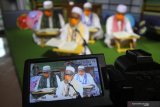 Peserta membaca Al Quran saat mengikuti khataman secara daring di Surabaya, Jawa Timur, Jumat (24/4/2020). Khataman Al Quran tersebut merupakan salah satu program Ngabuburit Daring Masjid Al Akbar Surabaya yang bertujuan untuk mengajak masyarakat tetap menjalankan ibadah di bulan Ramadhan 1441 Hijriah dari rumah masing-masing. Antara Jatim/Moch Asim/zk.