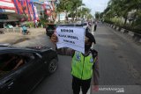 Petugas kepolisian memeriksa kendaraan bermotor saat Pembatasan Sosial Berskala Besar (PSBB) di perbatasan Kota Banjarmasin, Kalimantan Selatan, Jumat (24/4/2020). Pemerintah Kota Banjarmasin resmi menerapkan PSBB dalam rangka percepatan penangan COVID-19 selama 14 hari dimulai pada 24 April hingga 7 Mei 2020. Foto Antaranews Kalsel/Bayu Pratama S.