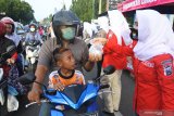 Polisi Wanita Polres Situbondo membagikan takjil ke pengendara di Jalan Raya Pantura Situbondo, Jawa Timur, Jumat (24/4/2020). Polisi Wanita dan Bhayangkari Polres Situbondo membagikan takjil ke pengendara motor, mobil, tukang becak menjelang berbuka puasa. Antara Jatim/Seno/zk