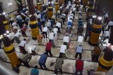 Umat Islam melaksanakan shalat Jumat di Masjid Agung Baitul Hakim, Kota Madiun, Jawa Timur, Jumat (24/4/2020). Shalat Jumat hari pertama Ramadhan 1441 Hijriah di masjid tersebut diikuti ratusan umat Islam dengan menerapkan physical distancing, mengenakan masker dan melewati bilik penyemprotan cairan disinfektan, serta dilakukan penyemprotan cairan disinfektan di masjid sebelumnya guna mencegah penyebaran COVID-19. Antara Jatim/Siswowidodo/zk