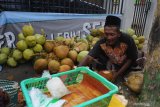 Pedagang membelah kelapa muda di Jalan Amin Jakfar, Pamekasan, Jawa Timur, Sabtu (25/4/2020). Memasuki bulan Ramadhan 1441 H. sejumlah pedagang kelapa muda mulai memenuhi beberapa sudut di kota itu. Antara Jatim/Saiful Bahri/zk.