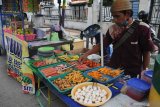 Pedagang menata makanan dagangannya di Jalan Trunojoyo, Pamekasan, Jawa Timur, Sabtu (25/4/2020). Menurut pedagang, penjualan makanan pada bulan puasa tahun ini menurun hingga 25 persen dibanding bulan puasa tahun lalu, karena ditutupnya lokasi bazar akibat pandemi COVID-19. Antara Jatim/Saiful Bahri/zk.