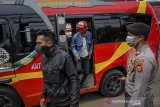 Petugas menurunkan penumpang di titik penyekatan larangan mudik di Jatinangor, perbatasan Kabupaten Bandung dan Kabupaten Sumedang, Jawa Barat, Sabtu (25/4/2020). Penyekatan oleh tim gabungan dari TNI, Polri, Dishub, dan Satpol PP tersebut dilakukan sebagai salah satu langkah penertiban larangan sementara penggunaan transportasi umum, kendaraan pribadi dan sepeda motor untuk mudik. ANTARA JABAR/Raisan Al Farisi/agr