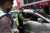 Polisi memeriksa KTP pengendara mobil berplat nomor luar daerah di Mengkreng, Kediri, Jawa Timur, Minggu (26/4/2020). Pemeriksaan (check point) di akses utama masuk Kediri tersebut dalam rangka pelarangan mudik guna menangkal penyebaran COVID-19. Antara Jatim/Prasetia Fauzani/zk.