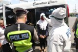 Polisi memeriksa suhu tubuh dan KTP penumpang mobil travel di Mengkreng, Kediri, Jawa Timur, Minggu (26/4/2020). Pemeriksaan (check point) di akses utama masuk Kediri tersebut dalam rangka pelarangan mudik guna menangkal penyebaran COVID-19. Antara Jatim/Prasetia Fauzani/zk.