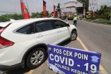 Polisi melarang masuk mobil berplat nomor luar daerah menuju Kediri yang dicurigai akan mudik di Kediri, Jawa Timur, Minggu (26/4/2020). Pemeriksaan (check point) di akses utama masuk Kediri tersebut dalam rangka pelarangan mudik guna menangkal penyebaran COVID-19. Antara Jatim/Prasetia Fauzani/zk.