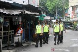 Polisi melakukan patroli penegakan aturan Pembatasan Sosial Berskala Besar (PSBB) di kawasan Pasar Sudi Mampir Banjarmasin, Kalimantan Selatan, Senin (27/4/2020). Kegiatan tersebut sebagai upaya POLRI untuk mendukung aturan pemerintah saat PSBB di Kota Banjarmasin serta memberikan edukasi tentang penanganan dan pencegahan penyebaran COVID-19 di tempat keramaian. Foto Antaranews Kalsel/Bayu Pratama S.