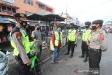 Polisi memberikan penjelasan mengenai aturan pemerintah kepada warga saat patroli penegakan aturan Pembatasan Sosial Berskala Besar (PSBB) di kawasan Pasar Baru Banjarmasin, Kalimantan Selatan, Senin (27/4/2020). Kegiatan tersebut sebagai upaya POLRI untuk mendukung aturan pemerintah saat PSBB di Kota Banjarmasin serta memberikan edukasi tentang penanganan dan pencegahan penyebaran COVID-19 di tempat keramaian. Foto Antaranews Kalsel/Bayu Pratama S.