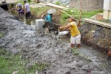 Pekerja mengerjakan proyek infrastruktur saluran air Program Padat karya Tunai (PDKT) yang dibiayai anggaran Dana Desa (DD) di Desa Bendiljati Wetan, Tulungagung, Jawa Timur, Selasa (28/4/2020). Pandemi corona memaksa pemerintah mengalihkan sebagian (sekitar 25-30 persen atau berkisar Rp24 triliun hingga Rp30 triliun) anggaran Dana Desa untuk Program Padat karya Tunai Desa (PDKT) yang sebelumnya dialokasikan total sebesar Rp72 triliun, untuk bantuan sosial meredam dampak tekanan ekonomi akibat pandemi COVID-19. Antara Jatim/Destyan Sujarwoko/zk.