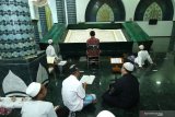 Umat muslim bertadarus membaca Al Quran raksasa di Masjid Baiturrahman, Banyuwangi, Jawa Timur, Senin (27/4/2020). Al Quran raksasa ditulis tangan oleh H Abdul Karim memiliki ukuran halaman 142 x 210 centimeter tersebut, mulai ditulis pada 1 Februari 2010 dan selesai pada 26 Agustus 2010 untuk dibaca setiap bulan Ramadan di Masjid Baiturrahman Banyuwangi Antara Jatim/Budi Candra Setya/zk