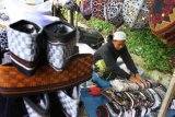 Pedagang musiman menata songkok jualannya di Sukun, Malang, Jawa Timur, Selasa (28/4/2020). Pedagang musiman setempat, mengaku penjualan pernik Ramadhan terutama songkok menurun 70 persen dibanding tahun lalu seiring adanya penerapan pembatasan jarak sosial serta himbauan tarawih di rumah dalam rangka pencegahan penyebaran COVID-19. ANTARA FOTO/Ari Bowo Sucipto/foc.