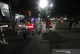 Pihak kepolisian melakukan penyekatan jalan keluar maupun masuk ke Kota di Jalan Ahmad Yani perbatasan Kota Banjarmasin, Kalimantan Selatan, Selasa (28/4/2020) malam. Untuk memaksimalkan Pembatasan Sosial Berskala Besar (PSBB) di Kota Banjarmasin pihak Kepolisian Resor Kota Banjarmasin memperketat pemberlakuan jam malam dengan dilakukan penyekatan jalan masuk ke dalam Kota dengan akses terbatas dan jalan keluar pada pukul 00.00 Wita hingga 06.00 Wita di tutup. Foto Antaranews Kalsel/Bayu Pratama S.