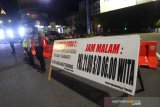 Polisi berjaga di ruas jalan Ahmad Yani yang di tutup saat pemberlakuan jam malam di Kota Banjarmasin, Kalimantan Selatan, Selasa (28/4/2020) malam. Untuk memaksimalkan Pembatasan Sosial Berskala Besar (PSBB) di Kota Banjarmasin pihak Kepolisian Resor Kota Banjarmasin memperketat pemberlakuan jam malam dengan dilakukan penyekatan jalan masuk ke dalam Kota dengan akses terbatas dan jalan keluar pada pukul 00.00 Wita hingga 06.00 Wita di tutup. Foto Antaranews Kalsel/Bayu Pratama S.