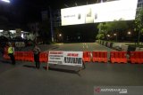 Polisi berjaga di ruas jalan Ahmad Yani yang di tutup saat pemberlakuan jam malam di Kota Banjarmasin, Kalimantan Selatan, Selasa (28/4/2020) malam. Untuk memaksimalkan Pembatasan Sosial Berskala Besar (PSBB) di Kota Banjarmasin pihak Kepolisian Resor Kota Banjarmasin memperketat pemberlakuan jam malam dengan dilakukan penyekatan jalan masuk ke dalam Kota dengan akses terbatas dan jalan keluar pada pukul 00.00 Wita hingga 06.00 Wita di tutup. Foto Antaranews Kalsel/Bayu Pratama S.