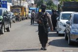 Polisi berjaga saat Detasemen Khusus (Densus) 88 Antiteror Polri menggeledah sebuah gudang ekspedisi di Jalan Kunti No 72, Surabaya, Jawa Timur, Kamis (30/4/2020). Penggeledahan dilakukan setelah Densus 88 Antiteror Polri menangkap seorang terduga teroris di tempat itu pada Kamis (23/4/2020) lalu. Antara Jatim/Didik/Zk