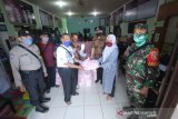 Lurah Kuripan Rusdiana (dua kanan) didampingi Camat Banjarmasin Timur Muzaiyin (tiga kanan) menyerahkan paket sembako bantuan dari Pemerintah Kota di Kantor Kelurahan Kuripan Banjarmasin, Kalimantan Selatan, Jumat (1/5/2020). Ratusan paket bantuan sembako tersebut akan didistribusikan oleh Pemerintah Kota Banjarmasin kepada masyarakat di Kelurahan Kuripan Kecamatan Banjarmasin Timur yang terdampak pandemi COVID-19. Foto Antaranews Kalsel/Bayu Pratama S.