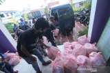 Petugas menata paket sembako bantuan dari Pemerintah Kota yang akan di bagikan kepada masyarakat di Kantor Kelurahan Kuripan Banjarmasin, Kalimantan Selatan, Jumat (1/5/2020). Ratusan paket bantuan sembako tersebut akan didistribusikan oleh Pemerintah Kota Banjarmasin kepada masyarakat di Kelurahan Kuripan Kecamatan Banjarmasin Timur yang terdampak pandemi COVID-19. Foto Antaranews Kalsel/Bayu Pratama S.