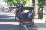 Sejumlah tukang becak menanti penumpang sambil menunggu harapan rezeki di bahu jalan Ahmad Yani, Banjarmasin, Kalimantan Selatan, Jumat (1/5/2020). Saat bulan suci Ramadhan banyak orang bersedekah dengan membagi bagikan makanan kepada kaum duafa, sehingga banyak warga yang kurang mampu menunggu harapan dari orang-orang yang bersedekah. Foto Antaranews Kalsel/Bayu Pratama S.