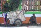 Warga bersantai di dekat gerobak sambil menunggu harapan rezeki di bahu jalan Gatot Subroto, Banjarmasin, Kalimantan Selatan, Jumat (1/5/2020). Saat bulan suci Ramadhan banyak orang bersedekah dengan membagi bagikan makanan kepada kaum duafa, sehingga banyak warga yang kurang mampu menunggu harapan dari orang-orang yang bersedekah. Foto Antaranews Kalsel/Bayu Pratama S.