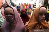 Pedagang menata busana muslim yang dijual di Pasar Sentra Antasari Banjarmasin, Kalimantan Selatan, Jumat (1/5/2020). Menurut pedagang setempat, omzet penjualan busana muslim pada bulan Ramadhan kali ini mengalami penurunan hingga 50 persen dari tahun lalu akibat dampak pandemi COVID-19 yang membuat masyarakat tidak keluar rumah. Foto Antaranews Kalsel/Bayu Pratama S.