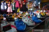 Penjual menata mainan kapal otok-otok di pasar tradisional Citra Niaga Kabupaten Jombang, Jawa Timur, Sabtu (2/5/2020). Meski mainan berbahan plastik membanjiri pasar, namun mainan tradisional kapal otok-otok berbahan dasar kaleng yang dijual R015 ribu-Rp20 ribu tergantung ukuran masih laku di pasaran. Antara Jatim/Syaiful Arif/