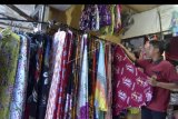 Pedagang menata mukena bermotif khas Bali yang dijual di kiosnya di Denpasar, Bali, Sabtu (2/5/2020). Menurut pedagang setempat, penjualan mukena bermotif khas Bali yang biasanya melonjak pada bulan Ramadhan, tahun ini mengalami penurunan sekitar 75 persen karena dampak pandemi COVID-19. ANTARA FOTO/Fikri Yusuf/nym.