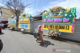 Warga melintas di dekat karangan bunga ucapan belasungkawa atas wafatnya KH Ahmad Zuhdianoor (Guru Zuhdi) di jalan Masuk Kediaman Guru Zuhdi di Banjarmasin, Kalimantan Selatan, Sabtu (2/5/2020). Guru Zuhdi salah satu ulama Kalimantan Selatan meninggal dunia di Rumah Sakit Medistra Jakarta. Foto Antaranews Kalsel/Bayu Pratama S.