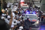 Warga menyaksikan iring-iringan mobil jenazah KH Ahmad Zuhdiannoor saat melintas di jalan menuju kediaman di Banjarmasin, Kalimantan Selatan, Sabtu (2/5/2020). Ulama karismatik KH Ahmad Zuhdiannoor atau yang akrab disapa Guru Zuhdi wafat pada usia 47 tahun pada hari Sabtu (2/5/2020) saat dalam penanganan medis di Rumah Sakit Medistra Jakarta. Foto Antaranews Kalsel/Bayu Pratama S.