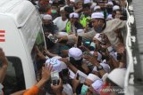 Warga menyaksikan iring-iringan mobil jenazah KH Ahmad Zuhdiannoor saat melintas di jalan menuju kediaman di Banjarmasin, Kalimantan Selatan, Sabtu (2/5/2020). Ulama karismatik KH Ahmad Zuhdiannoor atau yang akrab disapa Guru Zuhdi wafat pada usia 47 tahun pada hari Sabtu (2/5/2020) saat dalam penanganan medis di Rumah Sakit Medistra Jakarta. Foto Antaranews Kalsel/Bayu Pratama S.