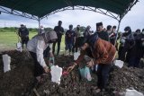 Keluarga mendiang musisi Erwin Prasetya menaburkan bunga di atas pusara saat proses pemakaman di TPU Keputih, Surabaya, Jawa Timur, Sabtu (2/5/2020).  Mantan gitaris bas grup band Dewa 19 tersebut meninggal dunia pada usia 48 tahun setelah dirawat di rumah sakit Sari Asih Ciputat karena menderita gangguan pada lambungnya. Antara Jatim/Moch Asim/zk.