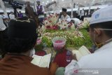 Santri membaca Al Quran di makam KH Ahmad Zuhdiannoor atau Guru Zuhdi di Aula Majta di dekat rumah duka di Banjarmasin, Kalimantan Selatan, Sabtu (2/5/2020). Proses pemakaman Guru Zuhdi tersebut hanya di saksikan oleh keluarga dan kerabat dekat saja untuk mencegah penyebaran COVID-19. Foto Antaranews Kalsel/Bayu Pratama S.