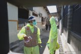 Petugas menggunakan baju APD (alat pelindung diri) lengkap berjalan memasuki gudang produksi pabrik rokok Mustika dan Trubus di Desa Gesikan, Tulungagung, Jawa Timur, Sabtu (2/5/2020). Sebanyak 214 buruh linting rokok di perusahaan rokok tersebut diperiksa secara tertutup dengan sarana medis Rapid Test (tes cepat) setelah sehari sebelumnya satu pekerja dinyatakan berstatus Pasien Dalam Pengawasan (PDP) COVID-19 karena menderita demam disertai pneumonia (radang saluran nafas atas), dan hasilnya 17 positif reaktif infeksi diduga virus corona baru. Antara Jatim/Destyan Sujarwoko/zk.