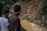 Warga melihat sejumlah makam yang rusak terdampak longsor di TPU Cikutra, Bandung, Jawa Barat, Sabtu (2/5/2020). Material longsor yang berasal dari tebing di kawasan TPU Cikutra tersebut mengakibatkan puluhan makam rusak dan serta sejumlah jenazah sempat terseret arus sungai sebelum dievakuasi oleh petugas pemakaman. ANTARA JABAR/Novrian Arbi/agr