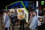 Polisi meminta keterangan dari sopir dan penumpang bus yang akan mudik saat operasi pengamanan dan penyekatan wabah COVID-19 di Badung, Bali, Minggu (3/5/2020). Bus yang membawa sekitar 39 penumpang menuju Sidoarjo, Jawa Timur itu digiring untuk menjalani pemeriksaan di Polres Badung karena surat izin jalan bermasalah dan diduga mengambil penumpang di luar terminal. ANTARA FOTO/Nyoman Hendra Wibowo/nym.