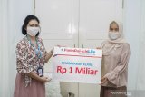 Wealth & Relationship Manager Panin Bank KCU Surabaya Hellynna Catur Wulandari (kiri) menyerahkan secara simbolis pembayaran klaim kepada ahli waris Ariani (kanan) di Surabaya, Jawa Timur, Selasa (5/5/2020). Pembayaran klaim sebesar Rp1 miliar tersebut merupakan manfaat dari produk Panin Premier Protection. Antara Jatim/Zk