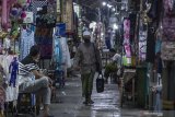 Pengunjung melintas di antara toko-toko di pasar sekitar kawasan wisata reliigi Masjid dan Makam Sunan Ampel, Surabaya, Jawa Timur, Selasa (5/5/2020). Para pedagang di kawasan tersebut mengaku pendapatan mereka menurun drastis karena sepinya pengunjung sejak pemberlakuan Pembatasan Sosial Berskala Besar (PSBB) di Surabaya Raya. Antara Jatim/Moch Asim/zk.