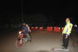 Personel polisi mengarahkan warga untuk putar balik di jalan Bojongsari, Indramayu, Jawa Barat, Rabu (6/5/2020) malam. beberapa titik jalan di kabupaten Indramayu ditutup mulai pukul 19.00 hingga 06.00 WIB seiring penerapan Pembatasan Sosial Berskala Besar (PSBB) guna memutus mata rantai pandemi COVID-19. ANTARA JABAR/Dedhez Anggara/agr