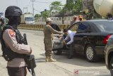 Petugas mengarahkan penumpang kendaraan roda empat untuk melakukan pembatasan sosial atau physical distancing yang akan melewati titik pemeriksaan di Gerbang tol Karawang Barat, Karawang, Jawa Barat, Rabu (6/5/2020). Petugas gabungan memperketat akses keluar masuk kendaraan yang akan melewati gerbang tol pada hari pertama pemberlakuan Pembatasan Sosial Berskala Besar (PSBB) di Karawang. ANTARA JABAR/M Ibnu Chazar/agr