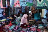 Pedagang batik menunggu pembeli di Pasar 17 Agustus, Pamekasan, Jawa Timur, Kamis (7/5/2020). Hingga pekan ke dua bulan puasa tahun ini penjualan batik Pamekasan sepi pembeli, karena pelanggan, seperti perusahaan dan perkantoran dari berbagai daerah yang biasa membeli dalam jumlah banyak untuk kebutuhan THR itu, terhenti akibat Pandemi COVID-19. Antara Jatim/Saiful Bahri/zk