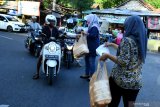 Anggota komunitas fotografi 'Bening' memberikan nasi bungkus kepada pengguna jalan di Pamekasan, Jawa Timur, Kamis (7/5/2020). Kegiatan itu sebagai bentuk kepedulian komunitas tersebut kepada masyarakat yang bekerja di luar rumah ditengah Pandemi COVID-19. Antara Jatim/Saiful Bahri/zk