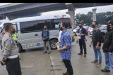 Petugas Kepolisian mengecek identitas TKI (Tenaga Kerja Indonesia) dari luar negeri di tol Jakarta-Cikampek di Cikarang Barat, Kabupaten Bekasi, Jawa Barat, Sabtu (9/5/2020). Direktorat Lalu Lintas (Dirlantas) Polda Metro Jaya akan menindak tegas kendaraan yang berupaya membawa penumpang keluar Jabodetabek dengan Undang- Undang nomor 22 tahun 2009 tentang Lalu Lintas dan Angkutan Jalan (LLAJ) saat penerapan larangan mudik. ANTARA FOTO/ Fakhri Hermansyah/nym