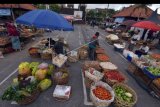 Sejumlah pedagang menyiapkan barang di lapak yang telah diatur jaraknya di area parkir Pasar Badung, Denpasar, Bali, Sabtu (9/5/2020). Pemerintah Kota Denpasar berencana menerapkan Pembatasan Kegiatan Masyarakat (PKM) untuk menekan angka penyebaran COVID-19 pada pertengahan bulan Mei 2020 menyusul banyaknya warga yang masih beraktivitas di luar rumah dan tidak disiplin melaksanakan protokol kesehatan. ANTARA FOTO/Nyoman Hendra Wibowo/nym