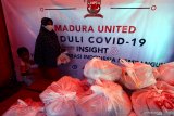 Warga mengambil paket sembako  yang disediakan Madura United Fc (MU) di Pamekasan, Jawa Timur, Sabtu (9/5/2020). MU menyalurkan 4.300 paket sembako kepada warga terdampak COVID-19. Antara Jatim/Saiful Bahri/zk