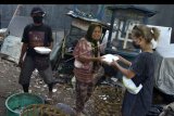 Relawan memberikan makanan secara gratis kepada warga yang membutuhkan di Badung, Bali, Minggu (10/5/2020). Warga dan relawan di kawasan tersebut mengumpulkan dan mengolah makanan bersama untuk dibagikan secara gratis kepada masyarakat yang perekonomiannya terdampak pandemi COVID-19. ANTARA FOTO/Fikri Yusuf/nym.