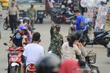 Petugas menertibkan warga yang tidak menggunakan masker saat melintas di jalan Yos Sudarso, Indramayu, Jawa Barat, Minggu (10/5/2020). Penertiban tersebut terkait penerapan Pembatasan Sosial Berskala Besar (PSBB) di Indramayu untuk memutus rantai penyebaran COVID-19. ANTARA JABAR/Dedhez Anggara/agr