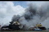 Petugas berusaha memadamkan api saat terbakarnya Kapal MT JAG LEELA di galangan kapal milik PT Waruna Nusa Sentana Shipyard, Belawan, Medan, Sumatera Utara, Senin (11/5/2020). Kapal MT JAG LEELA tersebut terbakar saat dalam proses perawatan. ANTARA FOTO/Irsan Mulyadi/nym.