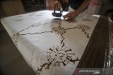 Perajin mencetak motif batik bergambarkan virus korona pada kain yang akan dijadikan baju di Batik Komar, Bandung, Jawa Barat, Senin (11/5/2020). Produksi batik bermotif virus korona tersebut merupakan salah satu bentuk keprihatinan perajin terhadap wabah COVID-19 serta salah satu ekspresi perajin untuk melawan COVID-19 dengan kreativitas. ANTARA JABAR/Raisan Al Farisi/agr
