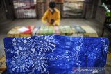 Pekerja merapikan baju motif batik bergambarkan virus korona di Batik Komar, Bandung, Jawa Barat, Senin (11/5/2020). Produksi batik bermotif virus korona tersebut merupakan salah satu bentuk keprihatinan perajin terhadap wabah COVID-19 serta salah satu ekspresi perajin untuk melawan COVID-19 dengan kreativitas. ANTARA JABAR/Raisan Al Farisi/agr