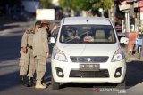 Sejumlah petugas Satpol PP meminta pengendara pengguna jalan untuk memutar arah saat penerapan Pembatasan Sosial Berskala Besar (PSBB) di Kota Gorontalo, Gorontalo, Senin (11/5/2020). Mulai pukul 17.00 Wita sejumlah jalan utama dan perbatasan di daeah itu ditutup seiring penerapan PSBB guna memutus mata rantai penyebaran pandemi COVID-19. (ANTARA FOTO/Adiwinata Solihin)